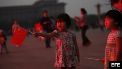 Una niña sujeta una bandera china en la plaza de Tiananmen, en Pekín (China), hoy, martes 4 de junio de 2013.