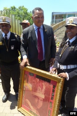 El reverendo y líder de los derechos civiles, Jesse Jackson (c), sostiene un cuadro con la imagen de su amigo el legendario campeón de boxeo Mohamed Alí.