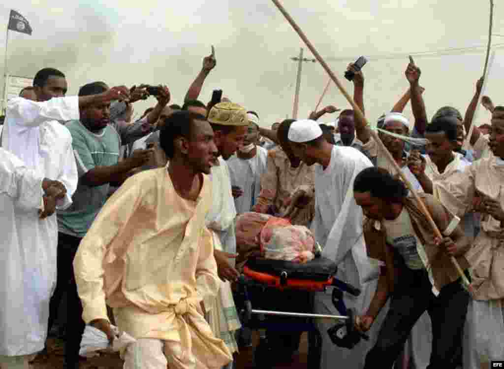 Unos sudaneses cargan con un muerto tras los enfrentamientos entre los musulmanes y el ejercito enfrente de la embajada de Alemania en Jartum, Sudán hoy, viernes 14 de septiembre de 2012. Decenas de manifestantes irrumpieron brevemente en la embajada del 