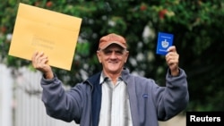 El cubano Pedro Ravelo muestra su pasaporte luego de recibir la visa de EEUU en la Embajada de EEUU en Bogotá el 22 de febrero de 2018. REUTERS/Jaime Saldarriaga 