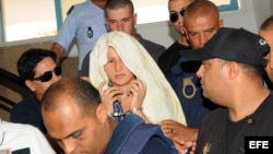 Archivo - Amina Sboui (c), integrante del grupo feminista ucraniano FEMEN, camina esposada antes de una audiencia ante un juez en Kairouan (Túnez). Cuatro activistas del grupo radical feminista, tres de ellas europeas y otra tunecina, comparecieron ante l