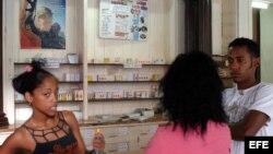 Tres jovenes conversan en una farmacia en La Habana,Cuba. 