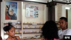 Tres jovenes conversan en una farmacia en La Habana,Cuba. 