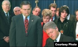 El presidente Bill Clinton promulga la Ley Helms-Burton. A su derecha los congresistas Ileana Ros-Lehtinen y Bob Menendez y el senador Jesse Helms