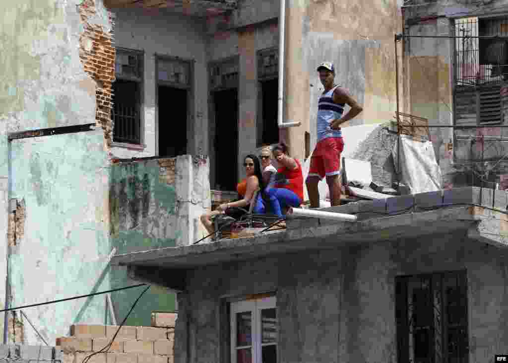 Cubanos miran la filmación de Fast & Furious desde un balcón destruido. 