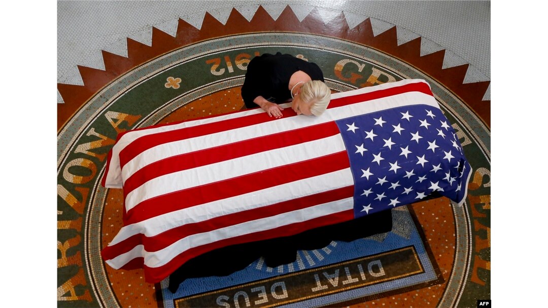 Cindy McCain, viuda de John McCain, llora sobre el féretro.