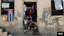 Dos hombres conversan en la entrada de una casa en la ciudad de Santiago de Cuba.