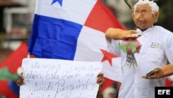 Un grupo de partidarios políticos y de la sociedad civil realizan una marcha con pancartas y muñecos en Panamá. 