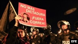 Una manifestante sostiene un cartel durante una protesta contra el Gobierno de Ecuador por dos proyectos legales sobre las herencias y la plusvalía inmobiliaria hoy, lunes 15 junio de 2015, en Quito (Ecuador). El presidente ecuatoriano Rafael Correa anunc