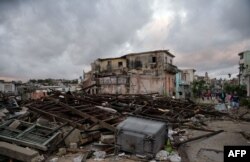 Habaneros caminan entre los escombros de sus casas destruidas tras el paso de un poderoso tornado que azotó la capital.
