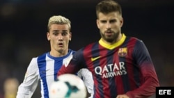 El defensa del FC Barcelona Gerard Piqué (d) y el centrocampista francés de la Real Sociedad Antoine Griezmann durante el partido de la sexta jornada de Liga de Primera División disputado esta tarde en el Camp Nou.