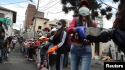 Ecuatorianos limpian las calles tras el último día de las protestas que dejaron 11 muertos por el alza del precio del combustible.