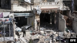 Varios combatientes del Ejército Libre Siro (ELS) rastrean un edificio en Alepo, Siria luego de bombardeos.