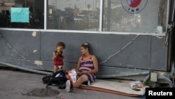 La cubana embarazada Viviana Martínez y su hijo de un año Sergio Rodríguez en espera de entrar a EEUU por el Puente Internacional Matamoros, Tamaulipas el 29 de junio 2019. REUTERS/Loren Elliott
