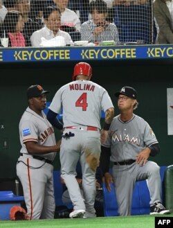 El manager de la MLB All Stars, Don Mattingly, de los Miami Marlins (der.) felicita a Yadier Molina, de los Cardinals de St. Louis, en un juego de exhibición en Tokio, en noviembre de 2018.