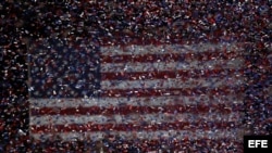 Tiras de confeti cubren el escenario donde el presidente Obama celebra con sus seguidores su reelección. 