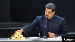 Nicolás Maduro toca una barra de oro mientras se dirige a los ministros responsables del sector económico en el Palacio de Miraflores. 