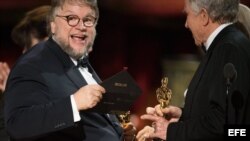 El director de cine mexicano Guillermo del Toro (izq) acepta el Óscar a la mejor película por "La forma del agua" ("The Shape of Water").