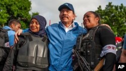 La policía nicaragüense se toma una foto con el presidente Daniel Ortega, luego de semanas de disturbios en Masaya, Nicaragua, el 13 de julio de 2018. (AP/Cristóbal Venegas).
