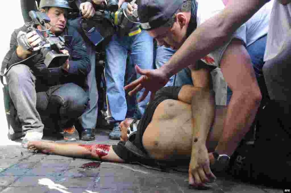 Un hombre yace en el piso luego de ser herido de bala durante una manifestación en Caracas.