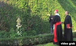 El cardenal Bertone, canciller emérito de El Vaticano, rocía con agua bendita la imagen de la Caridad del Cobre.
