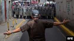 Un hombre protesta frente a miembros de la Policía Nacional Bolivariana, el 28 de diciembre de 2017, en Caracas.