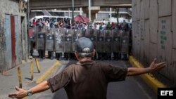 Un hombre protesta frente a miembros de la Policía Nacional Bolivariana. (Archivo)