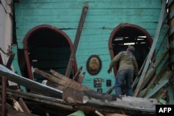 Un hombre intenta salvar sus pertenencias de un edificio destruido por el fuerte tornado que azotó La Habana.