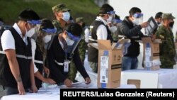 Miembros del Consejo Nacional Electoral de Ecuador preparan material para los comicios del 11 de abril de 2021.
