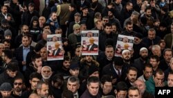 Manifestantes sostienen carteles con la imagen de Jamal Khashoggi en un funeral simbólico por el periodista asesinado. 