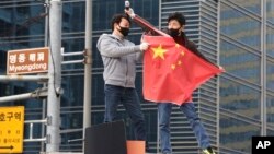 Manifestantes rasgan una bandera nacional china durante una manifestación para oponerse a una visita prevista por el canciller de ese país Wang Yi, cerca de la Embajada de China en Seúl.