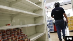 Un cliente recorre un pasillo con estanterías desabastecidas en un supermercado de Caracas (Venezuela).