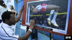 El plusmarquista mundial cubano de salto de altura Javier Sotomayor firma una fotografía.