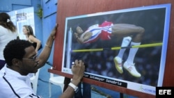 El plusmarquista mundial cubano de salto de altura Javier Sotomayor firma una fotografía.