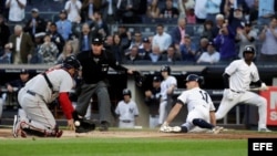 Brett Gardner (d) de Yanquis se desliza frente al receptor Sandy León (i) de Medias Rojas el miércoles 9 de mayo de 2018, en un juego de la MLB entre Medias Rojas de Boston y Yanquis de Nueva York en el estadio de Yanquis en Nueva York (EE.UU.). EFE/JASON