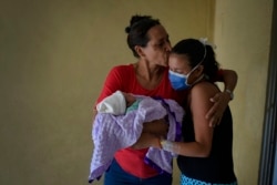 Nélida López besa a su hija, la madre primeriza Ada Mendoza,