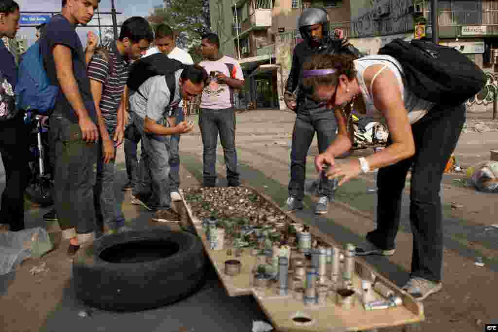 Varias personas observan los restos de las bombas lacrimógenas lanzadas en los últimos díasen la Plaza Altamira de Caracas (Venezuela).
