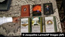 Kamaltürk Yalqun muestra los libros de su padre en abril de 2019 en Filadelfia. Yalqun Rozi, encarcelado en la República Popular China, dedicó su vida a la literatura y la educación uigures. Foto: © Jacqueline Larma/AP Images.
