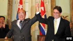 El canciller cubano, Bruno Rodríguez (d), toma la mano del ministro de Relaciones Exteriores de Corea del Norte, Pak Ui Chun (i).