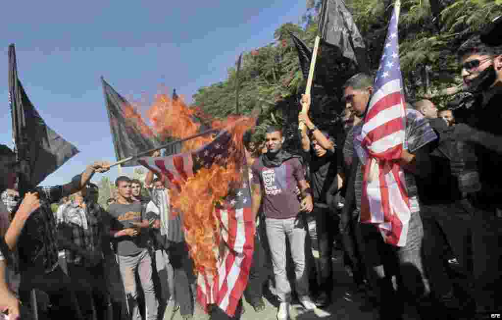 Unos musulmanes palestinos gritan consignas antiestadounidenses y queman una bandera estadounidense durante una concentración convocada enfrente de la sede de UNESCO en la Franja de Gaza hoy, miércoles 12 de septiembre de 2012.