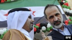 El presidente de la la opositora Coalición Nacional Siria (CNFROS), Ahmad Mouaz Al-Khati (d) escucha al ministro de Asuntos Exteriores de Catar, Khalid bin Mohammed Al-Attiyah (i) durante el acto de entrega de la la Embajada siria en Doha .