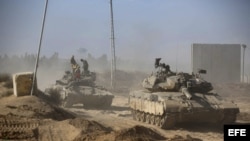 Varios soldados israelíes descansan encima de varios tanques en una zona de la franja de Gaza, al sur de Israel. 