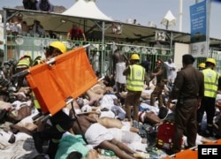 Miembros de los servicios de emergencia se abren paso entre los cadáveres tras una estampida de peregrinos en La Meca.