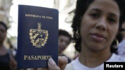 Una cubana muestra su pasaporte cubano obtenido en una oficina de inmigración en La Habana, Cuba. 