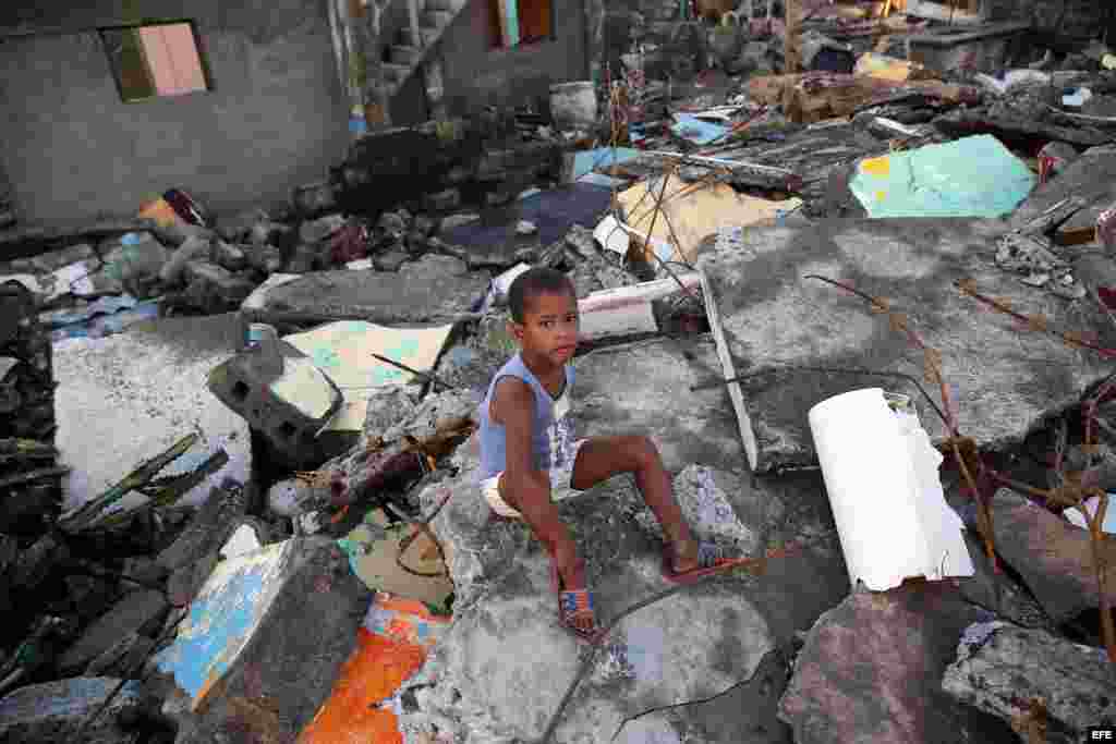 Un niño sentado en los escombros hoy, viernes 7 de octubre de 2016, tras el paso hace tres días del huracán Matthew en Baracoa (Cuba).EFE/Alejandro Ernesto