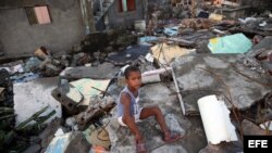 Un niño sentado en los escombros tras el paso del huracán Matthew en Baracoa. EFE/Alejandro Ernesto
