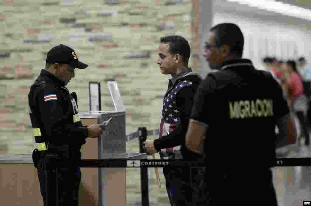 - Policías revisan a un migrante cubano hoy, martes 12 de enero de 2016, en el aeropuerto Daniel Oduber en Liberia (Costa Rica).