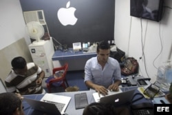 Un joven cubano atiende en su negocio de reparaciones de Iphones, en La Habana.
