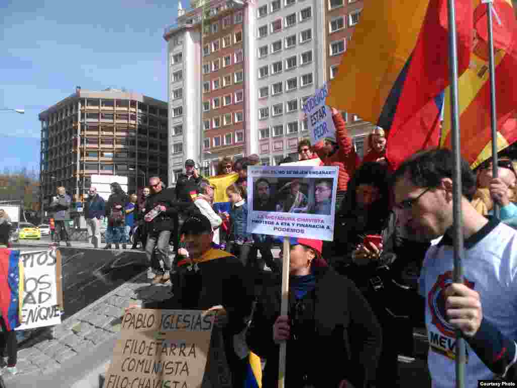 Manifestantes portan pancartas denunciando a miembros de Podemos