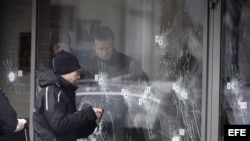 La policía forense inspecciona los agujeros de bala en la puerta del Café Krudttoenden en Copenhague.